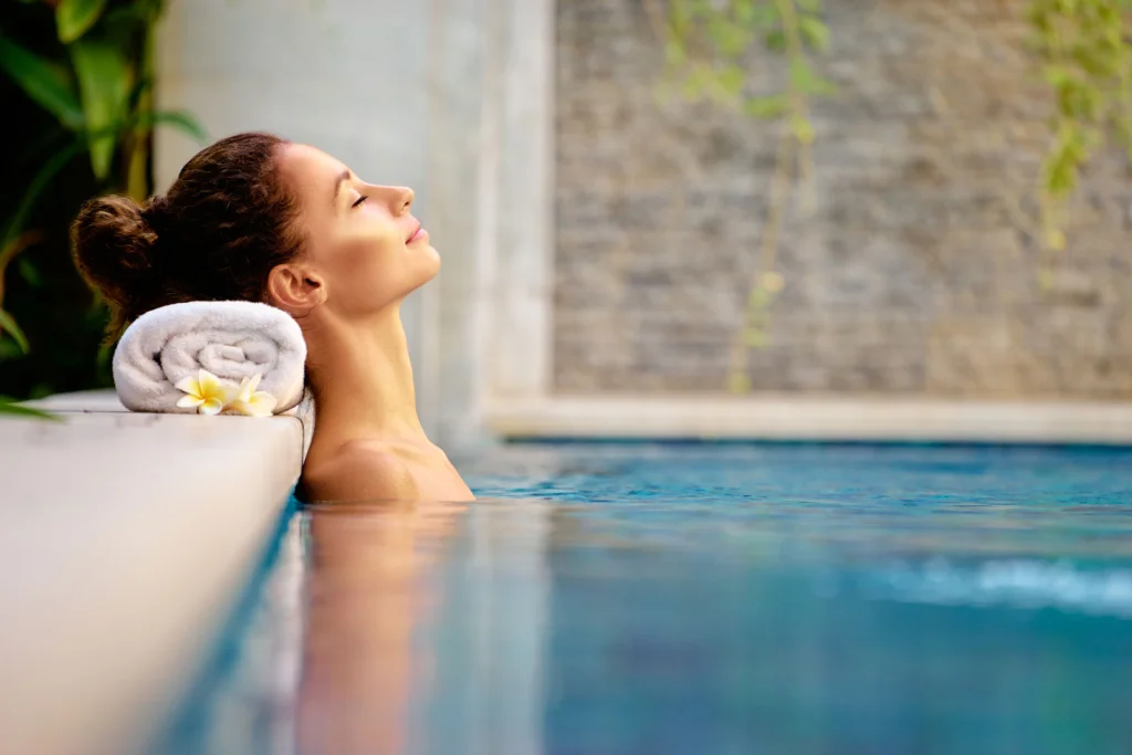 Woman relaxing in outdoor spa swimming pool